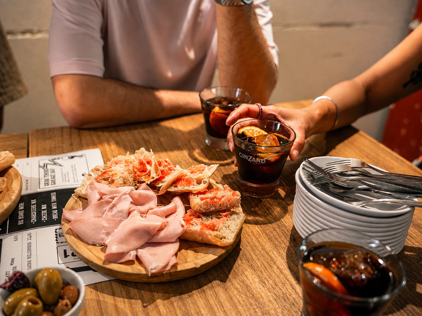 Pa amb tomàquet, charcuterie, olives and vermouth shared at a Barcelona table